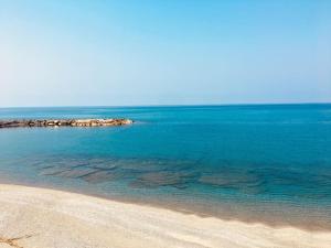 a beach with blue water and a group of rocks at Casa Alea - Appartamento turistico - Paola- in Paola