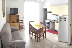 eine Küche und ein Wohnzimmer mit einem Tisch und einem Sofa in der Unterkunft Casa Alea - Appartamento turistico - Paola- in Paola