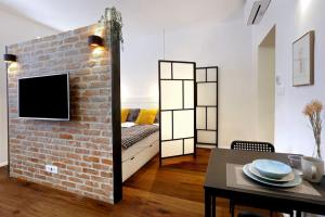 een woonkamer met een bakstenen muur en een tafel bij Wally apartment in Ljubljana