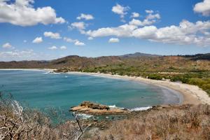 vistas a una playa con montañas en el fondo en EL TUMBO, en Rivas