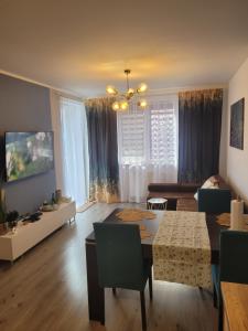 a living room with a table and a dining room at PAW Apartament 2 in Koszalin