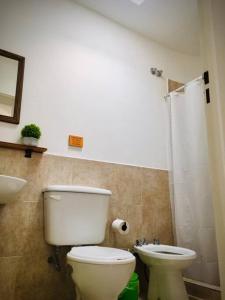 y baño con aseo blanco y lavamanos. en CasaNorte Hospedaje en Miraflores, Catamarca 