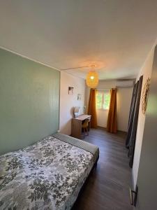 a small bedroom with a bed and a table at La Kaz Vert d’Õ in Saint-Denis