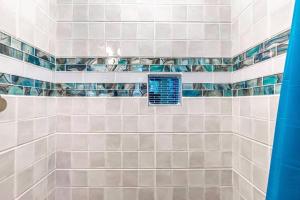 a bathroom with white tiles and a window at Creme de la Creme @ Graceland in Memphis