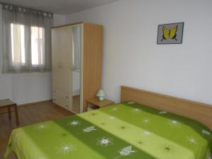 - une chambre avec un lit vert et une armoire dans l'établissement Apartments MB, à Pula