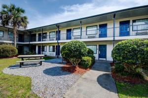 un edificio con un banco de picnic delante de él en Studio 6-Ocean Springs, MS, en Ocean Springs