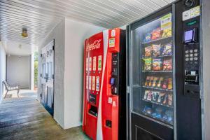 una máquina de soda de cocacola roja junto a una nevera en Studio 6-Ocean Springs, MS, en Ocean Springs