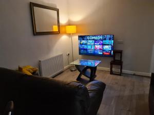 a living room with a couch and a television at Whole House - 4 Bedrooms - Parking - Sleeps 8 in Birmingham
