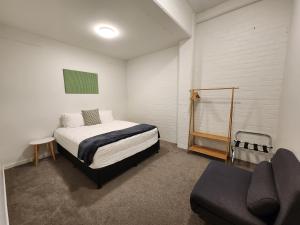 um quarto com uma cama e um sofá em U Suites on Webb em Wellington