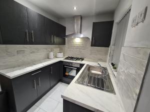 a kitchen with a sink and a stove at Whole House - 4 Bedrooms - Parking - Sleeps 8 in Birmingham