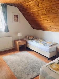 a bedroom with a bed and a wooden ceiling at Summerside Apartman Harkány in Harkány