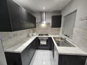 a large kitchen with a sink and a stove at Whole House - 4 Bedrooms - Parking - Sleeps 8 in Birmingham