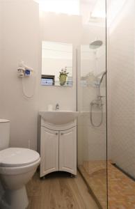 een badkamer met een toilet, een wastafel en een douche bij Lovely City Center Apartment - Free Minibar in Boekarest