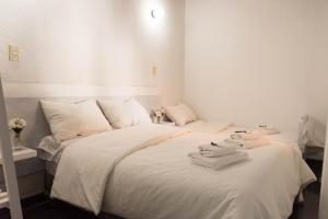 ein Schlafzimmer mit einem weißen Bett mit Handtüchern darauf in der Unterkunft El Bonito Salta in Salta