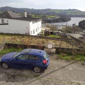 a blue car parked on the side of a house at A Casa da Esquina in Portomarin