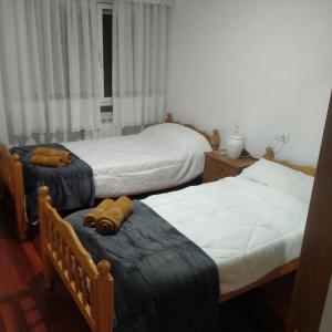1 dormitorio con 2 camas individuales y 2 mesas en A Casa da Esquina, en Portomarín