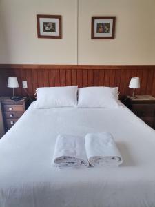 a white bed with two towels on top of it at Departamento Rossbach in Puerto Puyuhuapi