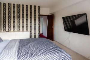 a bedroom with a bed and a flat screen tv at Parliament Merlot Unirii Square 5 Bedrooms Luxury Apartment Old Town in Bucharest