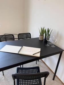 uma mesa preta com copos de vinho e um caderno em Sonniges Apartment mit Balkon em Graz
