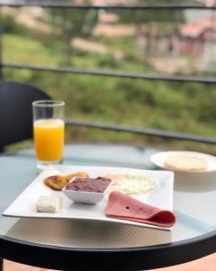 een tafel met een bord eten en een glas sinaasappelsap bij Hotel Boutique Los Pinos in Santa Rosa de Copán
