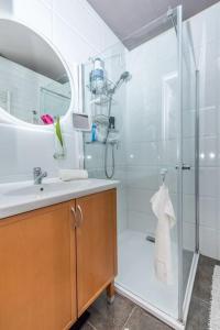 ein Bad mit einer Dusche, einem Waschbecken und einem Spiegel in der Unterkunft Szabi Buda New Terrace in Budapest