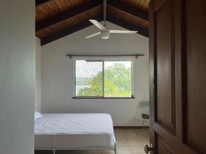 um quarto com uma cama e uma janela em TRADEWINDS VILLAS em Port Vila