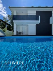 a villa with a swimming pool in front of a house at CASHMERE Premium Apartment in Siófok
