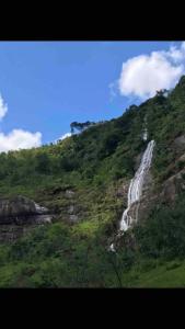 une cascade sur le côté d'une montagne dans l'établissement Refúgio, Aconchego, Aonde nasce o sol e Cachoeira!, à Mercês