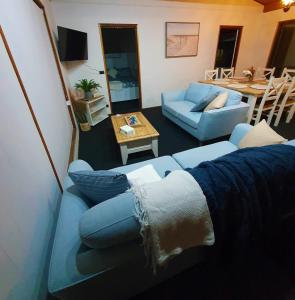 ein Wohnzimmer mit einem blauen Sofa und einem Tisch in der Unterkunft Karoa in Wallaroo