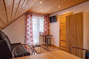 ein Esszimmer mit einem Tisch, Stühlen und einem Fenster in der Unterkunft Cichy Potok in Polańczyk