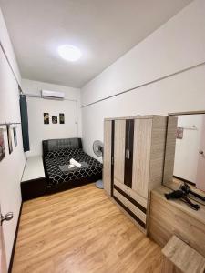 サンダカンにあるKW HOMESTAY CASA UNO APARTMENTのベッド1台が備わるウッドフロアの小さな客室です。