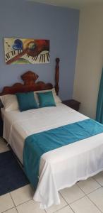 Schlafzimmer mit einem Bett in Blau und Weiß in der Unterkunft Melrose Place in Montego Bay
