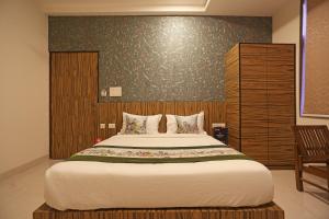 1 dormitorio con 1 cama grande y pared de madera en Capital O Swastika, en Jaipur