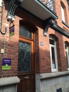 a brick building with a door with a sign on it at Chambres et Table d'hôtes La Belle Lensoise in Lens