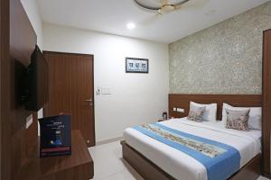 a bedroom with a bed and a flat screen tv at Super Capital O Hotel Swastika in Jaipur