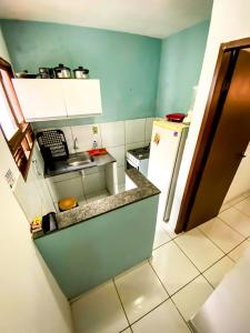 una pequeña cocina con fregadero y nevera. en Apartamento Mobiliado Mozart, en Natal