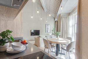 een keuken en een woonkamer met een tafel en stoelen bij Metropolitan Boutique in A Coruña