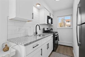een witte keuken met een wastafel en een koelkast bij Bright & Spacious 2 Bedroom, Quiet in Mount Clemens