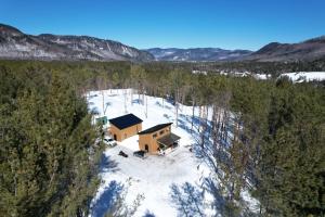 une vue aérienne sur une cabine dans la neige dans l'établissement Vallée bras du Nord Jumeau #1 avec spa, à Saint-Raymond