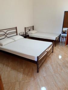 un grupo de 3 camas en una habitación en Ενοικιαζόμενα Δωμάτια Γεωργία Σταμούλου, en Rovies