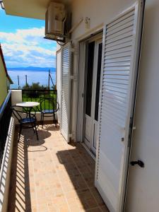 a balcony with a table and a table at Ενοικιαζόμενα Δωμάτια Γεωργία Σταμούλου in Rovies