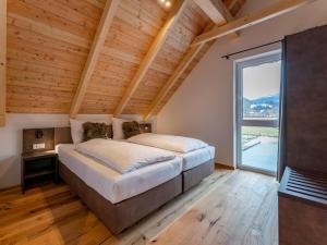 a bedroom with a large bed and a large window at Mountain Chalet Arnica in Sankt Lorenzen ob Murau