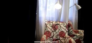 a chair sitting in front of a window with curtains at Belvoir Estate Serviced Apart-Hotel & Residence in Freetown