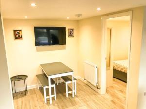 a room with a table and a television and a bed at Badgers Sett 2 Bedroom sleeps 4, The New Inn Viney Hill, Forest of Dean in Blakeney