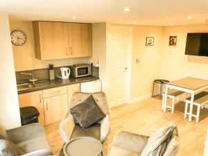 a living room with a couch and a kitchen with a table at Badgers Sett 2 Bedroom sleeps 4, The New Inn Viney Hill, Forest of Dean in Blakeney
