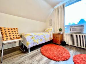 um quarto com uma cama, uma janela e um tapete vermelho em Private Room with 2 Twin Beds- Air Conditioning and Shared Bathrooms em Seattle