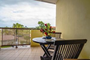 - une table avec un vase de fleurs sur le balcon dans l'établissement Bel appartement T2 * Netflix * Terrasse* Parking, à Kourou