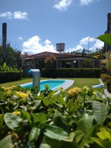 une cour avec une piscine et une maison dans l'établissement Chalés do Porto, à Porto de Pedras