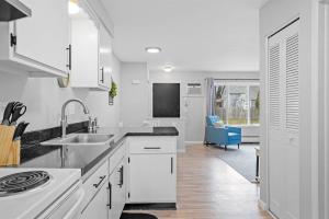 cocina blanca con fregadero y fogones en Quiet & Cozy End Unit Near Downtown Mount Clemens, en Mount Clemens