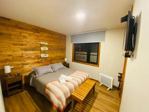 a bedroom with a bed with a wooden wall at Albergo B&B in Panguipulli